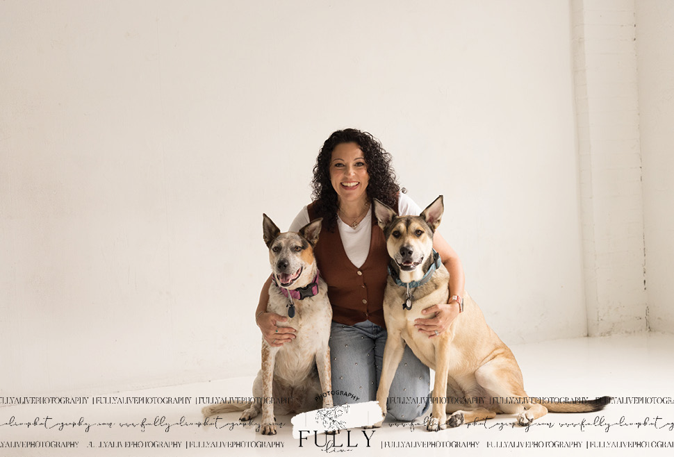 couple in a studio with their dogs enjoying a family photoshoot